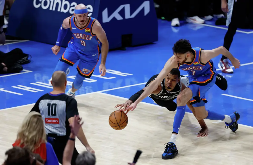 San Antonio Spurs forward Victor Wembanyama (1) and Oklahoma City Thunder center Chet Holmgren (7) dive for a loose ball during the second overtimed of Game 1 of the Western Conference Finals at Paycom Center in Oklahoma City, Monday, May 18, 2026. The Spurs defeated the Thunder 122-115 in double overtime.