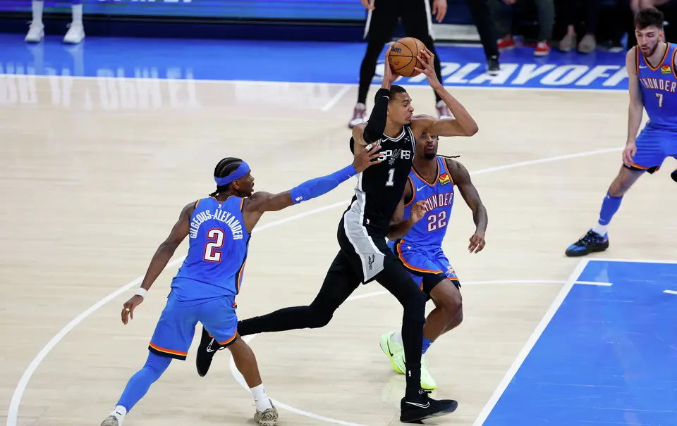 San Antonio Spurs forward Victor Wembanyama (1) drives to the basket for a dunk past Oklahoma City Thunder guard Shai Gilgeous-Alexander (2) and Oklahoma City Thunder guard Cason Wallace (22) during the second half of Game 1 of the Western Conference Finals at Paycom Center in Oklahoma City, Monday, May 18, 2026. The Spurs defeated the Thunder 122-115 in double overtime.