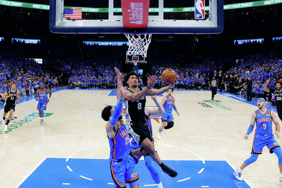 San Antonio Spurs guard Dylan Harper (2) lays the ball in over Oklahoma City Thunder guard Ajay Mitchell (25) during Game 1 of the Western Conference Finals at Paycom Center in Oklahoma City, Monday, May 18, 2026. The Spurs defeated the Thunder 122-115 in double overtime.