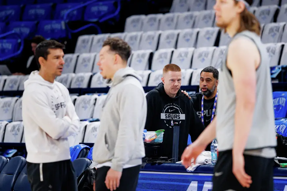 San Antonio Spurs associate head coach Sean Sweeney, center left, talks to Spurs general manager Brian Wright as the team participates in shootaround at Paycom Center in Oklahoma City, Wednesday, May 20, 2026, to prepare for Game 2 of the Western Conference Finals against the Oklahoma City Thunder.