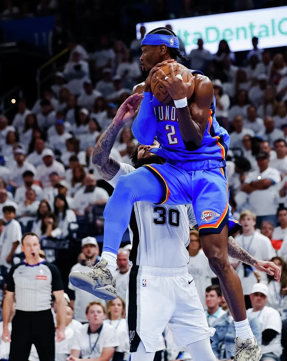 Oklahoma City Thunder guard Shai Gilgeous-Alexander (2) leaps around San Antonio Spurs forward Julian Champagnie (30) during the third quarter of Game 2 of the Western Conference Finals at Paycom Center in Oklahoma City, Wednesday, May 20, 2026.