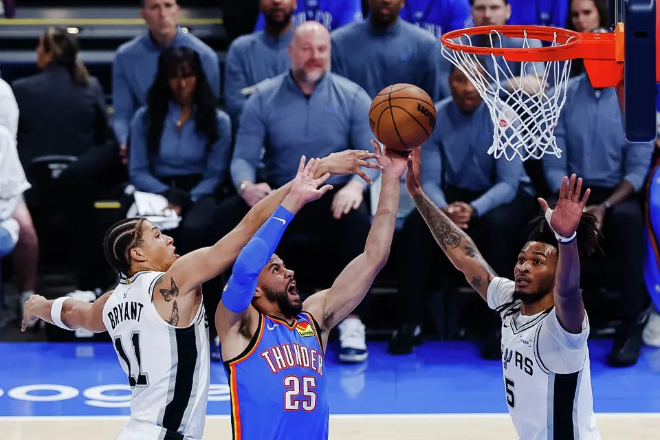 San Antonio Spurs forward Carter Bryant (11) and San Antonio Spurs guard Stephon Castle (5) guard Oklahoma City Thunder guard Ajay Mitchell (25) during the first half of Game 2 of the Western Conference Finals at Paycom Center in Oklahoma City, Wednesday, May 20, 2026.