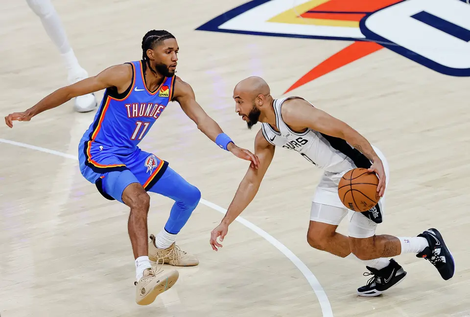 San Antonio Spurs guard Jordan McLaughlin (0) dribbles around Oklahoma City Thunder guard Isaiah Joe (11) during the first half of Game 2 of the Western Conference Finals at Paycom Center in Oklahoma City, Wednesday, May 20, 2026.