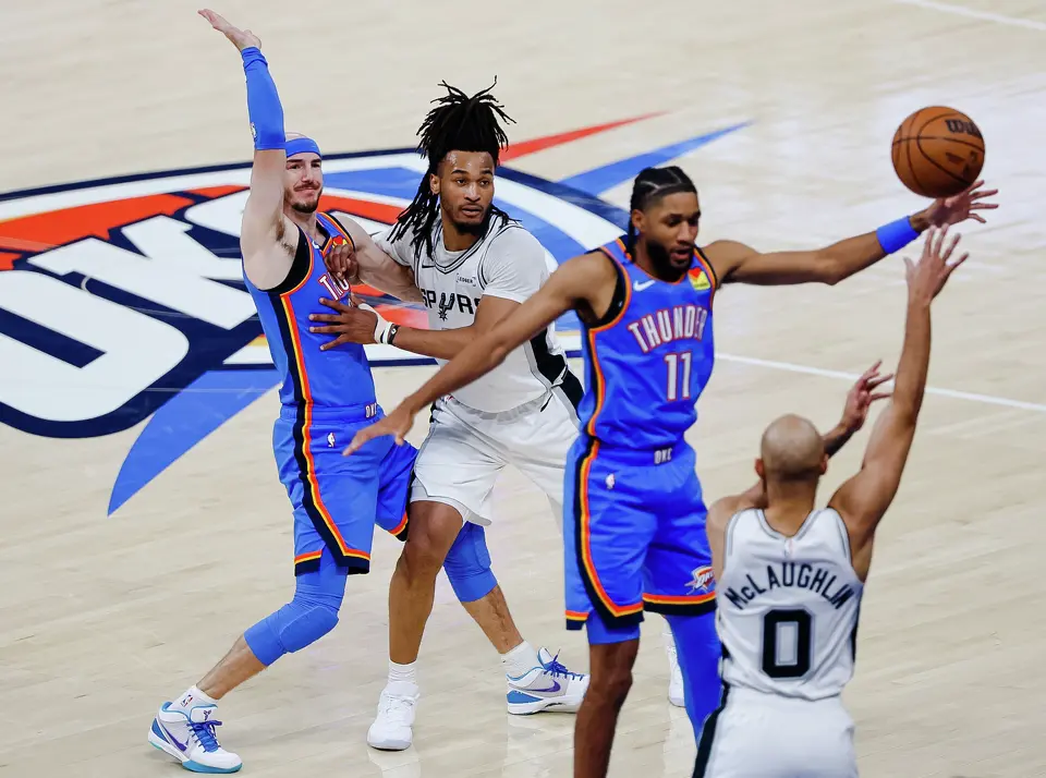 San Antonio Spurs guard Jordan McLaughlin (0) passes the ball while San Antonio Spurs guard Stephon Castle (5) guards Oklahoma City Thunder guard Alex Caruso (9) during the first half of Game 2 of the Western Conference Finals at Paycom Center in Oklahoma City, Wednesday, May 20, 2026.