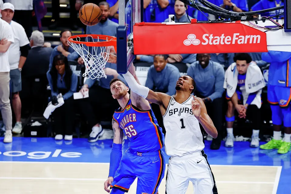 San Antonio Spurs forward Victor Wembanyama (1) reaches around Oklahoma City Thunder center Isaiah Hartenstein (55) during the fourth quarter of Game 2 of the Western Conference Finals at Paycom Center in Oklahoma City, Wednesday, May 20, 2026. The San Antonio Spurs fell 122-113 to the Oklahoma City Thunder.