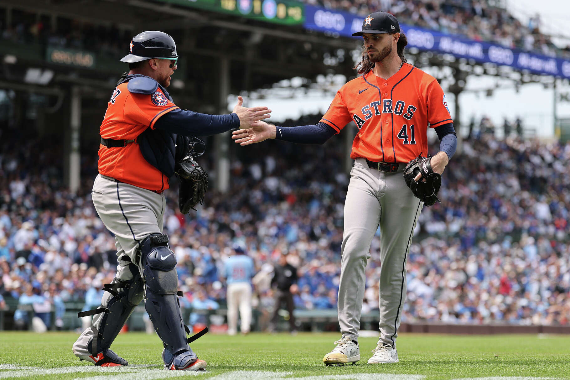 Spencer Arrighetti (right) of the Houston Astros high fives Christian Vázquez (left) against the Chicago Cubs during the third inning at Wrigley Field on May 22, 2026 in Chicago, Illinois. (Photo by Michael Reaves/Getty Images)