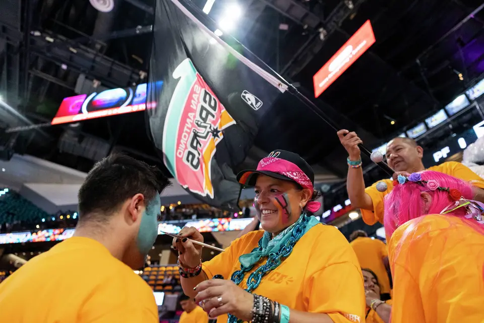 Jennifer Montes paints the face of Matthew Vasquez prior to the start of Game 3 of the Western Conference Finals at Frost Bank Center in San Antonio on Friday, May 22, 2026.
