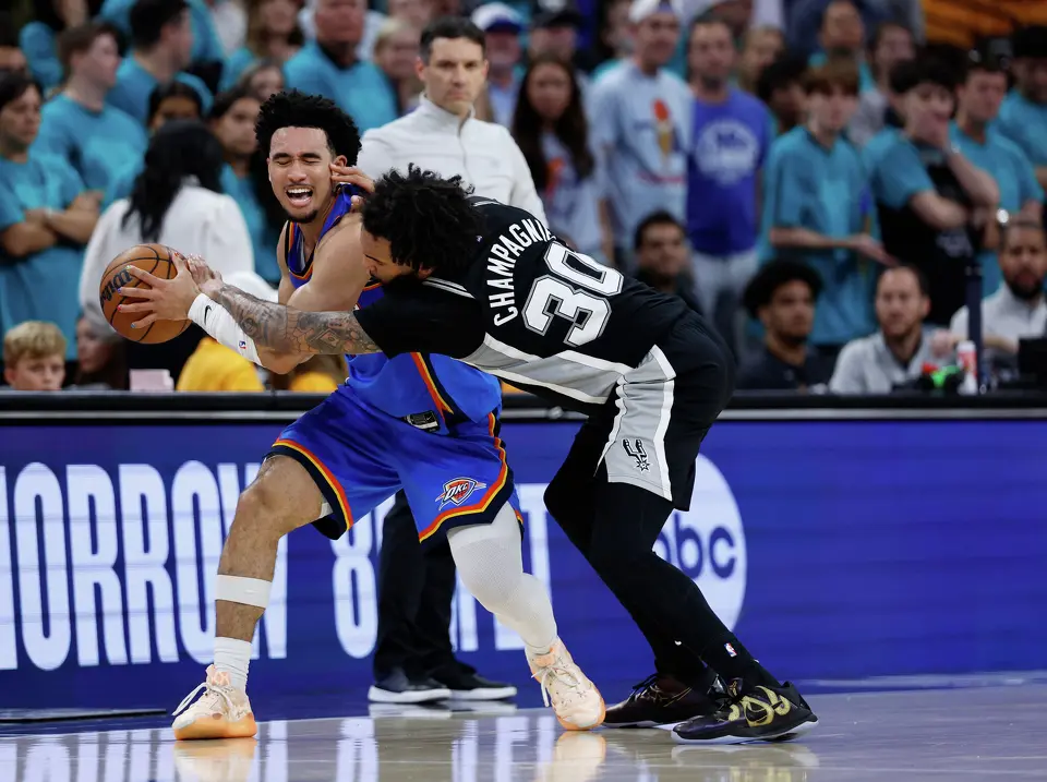 San Antonio Spurs forward Julian Champagnie (30) fouls Oklahoma City Thunder guard Jared McCain (3) during the second half of Game 3 of the Western Conference Finals at Frost Bank Center in San Antonio, Friday, May 22, 2026. The Spurs fell 123-108 to the Thunder, who now lead the series 2-1.