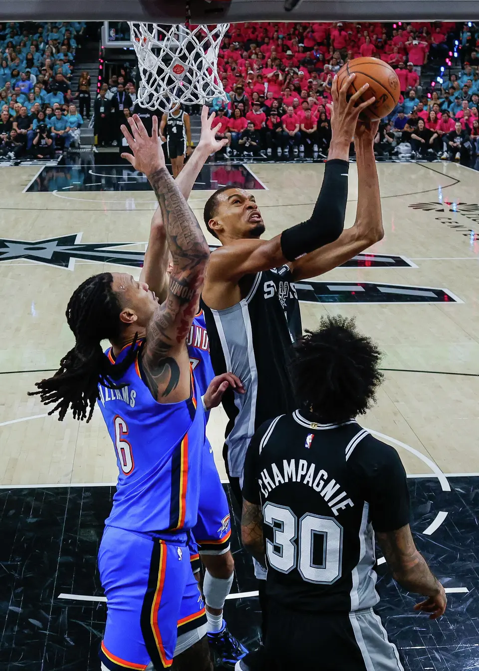 San Antonio Spurs center Victor Wembanyama (1) goes up for a shot over Oklahoma City Thunder forward Jaylin Williams (6) and center Chet Holmgren (7) during Game 3 of the Western Conference Finals at Frost Bank Center in San Antonio, Friday, May 22, 2026. The Spurs fell 123-108 to the Thunder, who now lead the series 2-1.