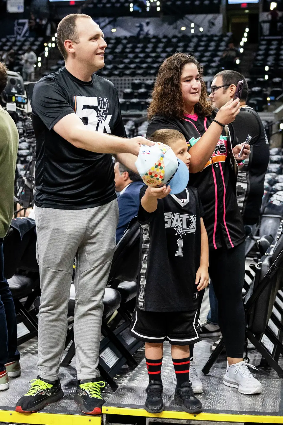 Kyle and Rita Willman stand with their son Ezra Willman, 5, while waiting for players prior to the start of Game 4 of the Western Conference Finals at Frost Bank Center in San Antonio on Sunday, May 24, 2026.