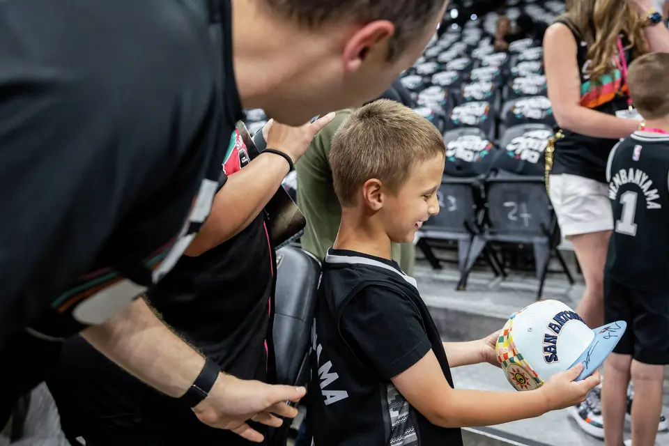 Ezra Willman, 5, reacts after San Antonio Spurs guard Stephon Castle (5) signed a hat prior to the start of Game 4 of the Western Conference Finals at Frost Bank Center in San Antonio on Sunday, May 24, 2026.