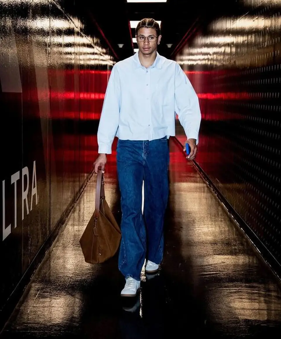 Carter Bryant arrives at Frost Bank Center wearing a light blue button-up shirt and jeans before Game 4 against the Oklahoma City Thunder.