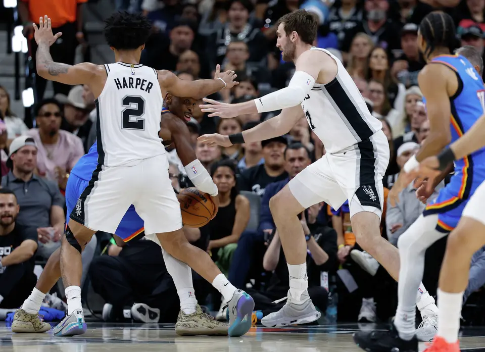 Oklahoma City Thunder guard Shai Gilgeous-Alexander (2) gets boxed in by San Antonio Spurs guard Dylan Harper (2) and San Antonio Spurs center Luke Kornet (7) during the third quarter of Game 4 of the Western Conference Finals at Frost Bank Center in San Antonio, Sunday, May 24, 2026.