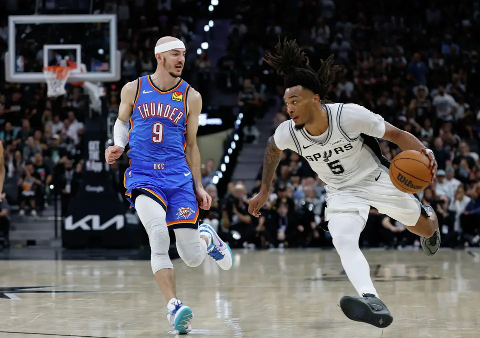 San Antonio Spurs guard Stephon Castle (5) rounds the outside with Oklahoma City Thunder guard Alex Caruso (9) in tow during the third quarter of Game 4 of the Western Conference Finals at Frost Bank Center in San Antonio, Sunday, May 24, 2026.