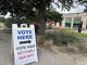 A sign directs voters to a polling place.