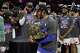 New York Knicks guard Jalen Brunson, center, holds the Eastern Conference Championship trophy after Game 4 in the Eastern Conference finals NBA basketball playoffs series against the Cleveland Cavaliers in Cleveland, Monday, May 25, 2026.