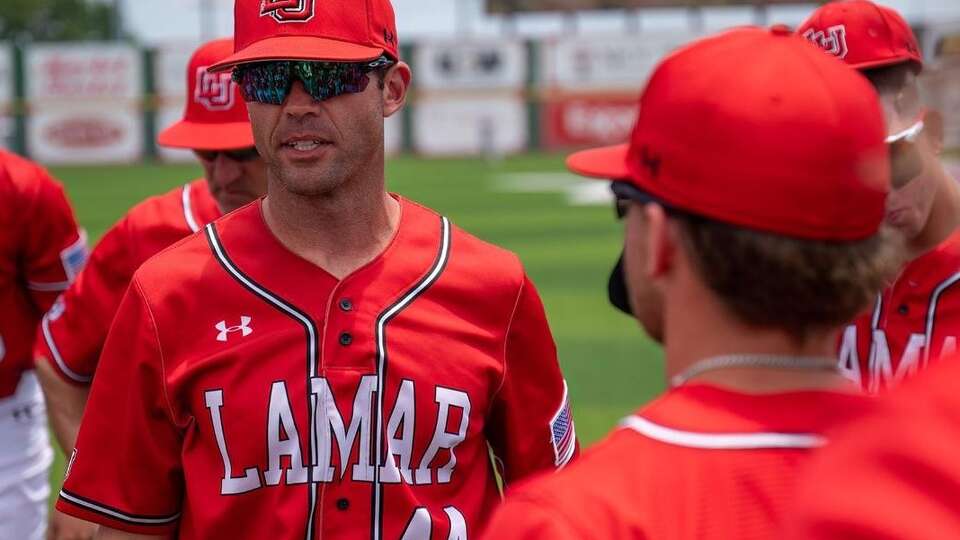 Lamar University head baseball coach Will Davis is shown with Cardinal players at Vincent-Beck Stadium in Beaumont.