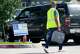 A poll worker carries a voting machine to a vehicle for curbside voting outside the Sunnyside Multi-Service Center during the primary runoff election in Houston Tuesday, May 26, 2026.