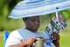 Jayla Randolph takes a water break under an umbrella while handing out campaign information at the Sunnyside Multi-Service Center during the primary runoff election in Houston Tuesday, May 26, 2026.