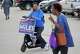 Melanie Miles rides a scooter as she campaigns for Justice of the Peace, Precinct 7, Place 2 outside the Sunnyside Multi-Service Center during the primary runoff election in Houston Tuesday, May 26, 2026.