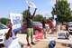 Volunteers wave signs outside of Fretz Park library during primary election runoff day, on Tuesday, May 26, 2026.
