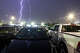 Lightning flashes over vehicles outside B&N Sports Bar in San Antonio as severe storms moved through the area during a tornado warning Tuesday night, May 26 2026.