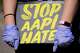 FILE - A person holds a sign and attends a rally to support Stop AAPI (Asian Americans and Pacific Islanders) Hate at the Logan Square Monument in Chicago, March 20, 2021.