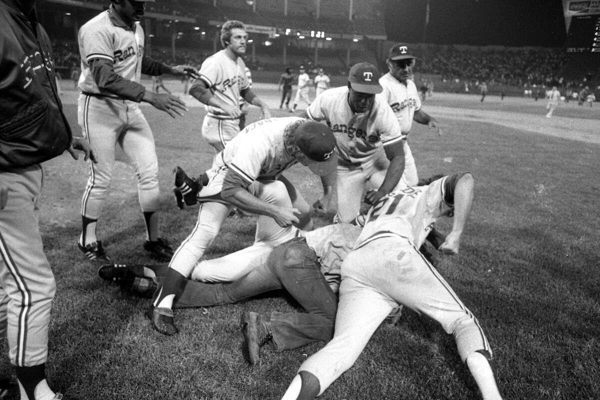 Members of the Texas Rangers take down a drunken fan who ran onto the field during a game against the Cleveland Indians on June 4, 1974 at Cleveland Municipal Stadium in Cleveland, Ohio.