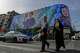 People cross an intersection in front of a billboard showing a portrait of the late Iranian President Ebrahim Raisi, who was killed in a helicopter crash in 2024, in downtown Tehran, Iran, Thursday, May 28, 2026.