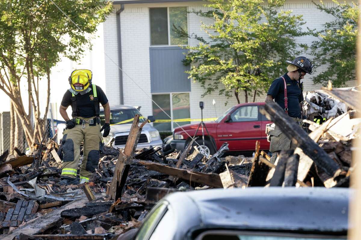 Dallas Fire-Rescue comb through the debris of a collapsed apartment complex in the 400 block of east 9th Street in Oak Cliff in Dallas, Friday, May 29, 2026. Officials said at least three people died and several were injured after an explosion at an apartment building in north Oak Cliff on Thursday.