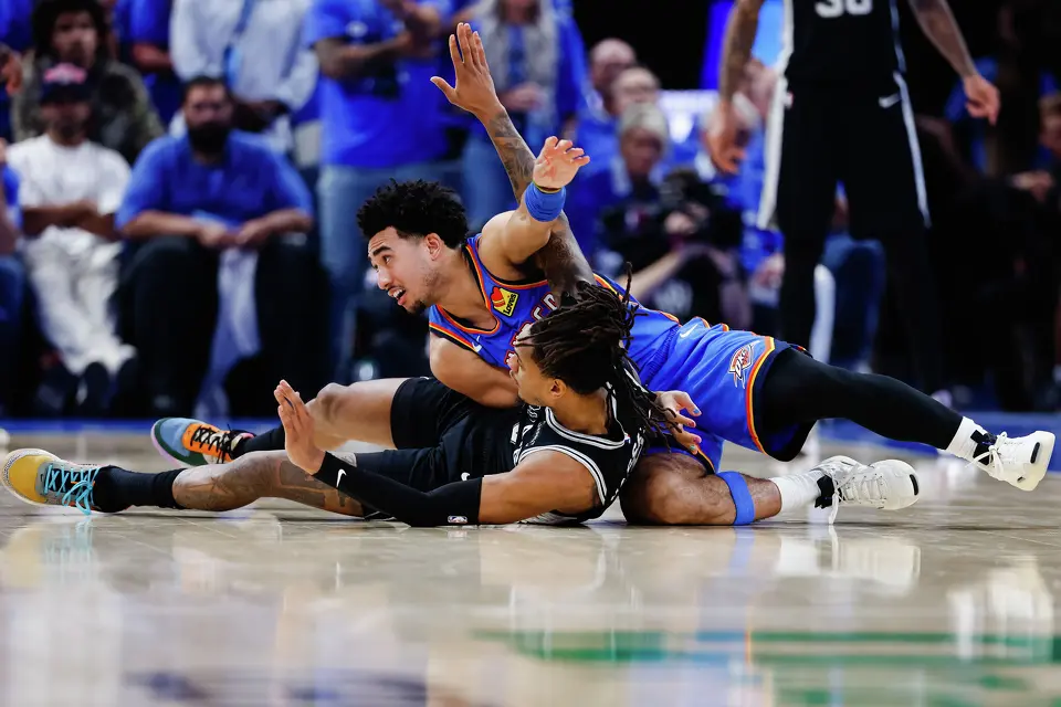 Oklahoma City Thunder guard Jared McCain (3) falls over San Antonio Spurs guard Devin Vassell (24) during the third quarter of Game 7 of the Western Conference Finals at Paycom Center in Oklahoma City, Saturday, May 30, 2026.