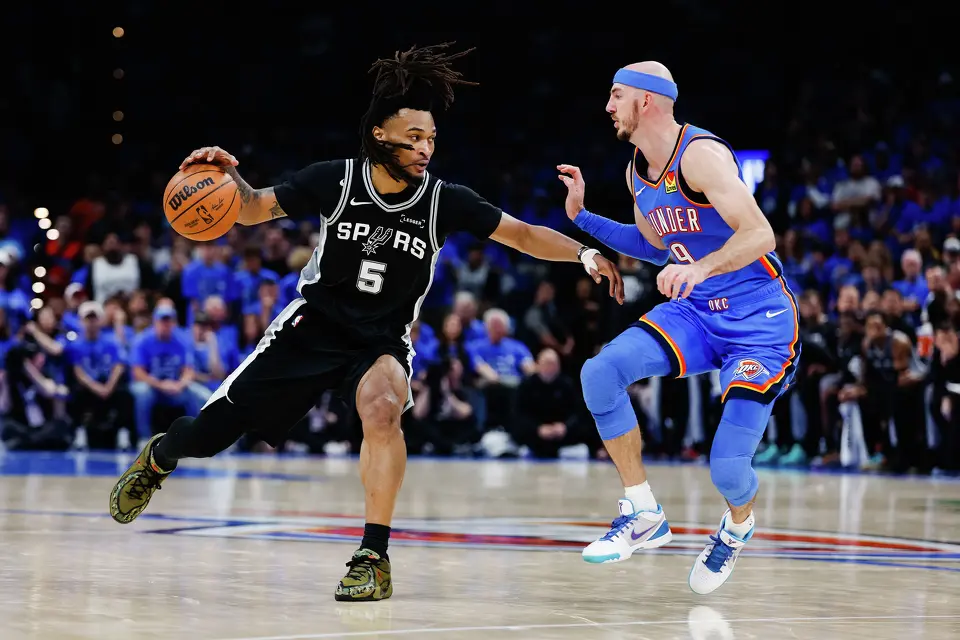 San Antonio Spurs guard Stephon Castle (5) dribbles past Oklahoma City Thunder guard Alex Caruso (9) during the third quarter of Game 7 of the Western Conference Finals at Paycom Center in Oklahoma City, Saturday, May 30, 2026.