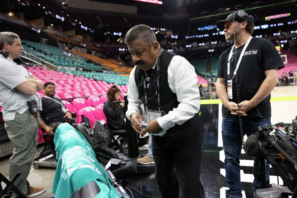 Freddie Ordones places NBA rule sheets on court-side seats during Game 1 of the NBA Finals at Frost Bank Center in San Antonio, Wednesday, June 3, 2026.