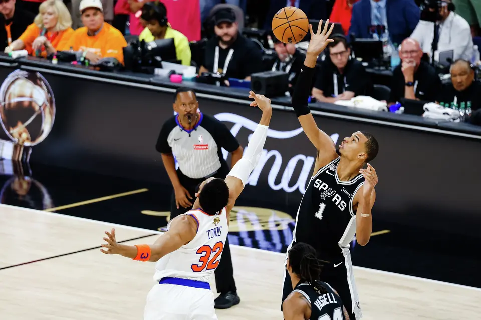 San Antonio Spurs center Victor Wembanyama (1) and New York Knicks center Karl-Anthony Towns (32) reach for the ball during the first quarter of Game 1 of the NBA Finals at Frost Bank Center in San Antonio, on Wednesday, June 3, 2026.