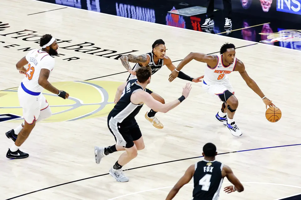 New York Knicks forward Og Anunoby (8) drives the ball while defended by San Antonio Spurs guard Devin Vassell (24) and San Antonio Spurs center Luke Kornet (7) during the first quarter of Game 1 of the NBA Finals at Frost Bank Center in San Antonio, on Wednesday, June 3, 2026.