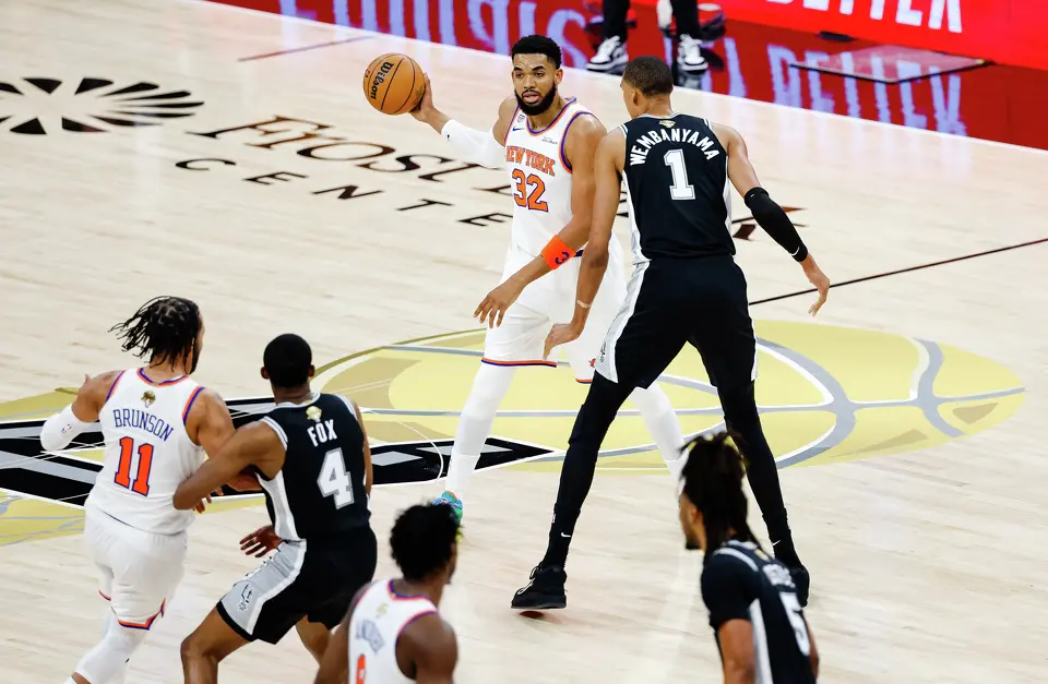 New York Knicks center Karl-Anthony Towns (32) looks to make a pass around San Antonio Spurs center Victor Wembanyama (1) during Game 1 of the NBA Finals at Frost Bank Center in San Antonio, on Wednesday, June 3, 2026.