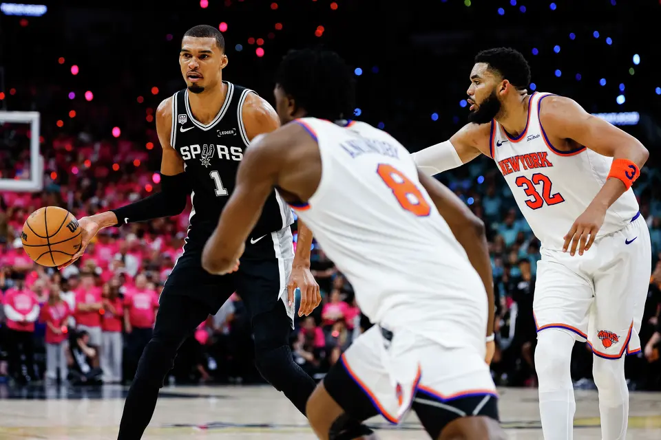 San Antonio Spurs center Victor Wembanyama (1) dribbles around New York Knicks forward Og Anunoby (8) and center Karl-Anthony Towns (32) during Game 1 of the NBA Finals at Frost Bank Center in San Antonio, on Wednesday, June 3, 2026.