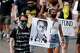 FILE - A demonstrator carries an image of Elijah McClain during a rally and march, June 27, 2020, in Aurora, Colo. Two paramedics were convicted Friday, Dec. 22, 2023, in the 2019 killing of McClain, who they injected with an overdose of the sedative ketamine after police put him in a neck hold.