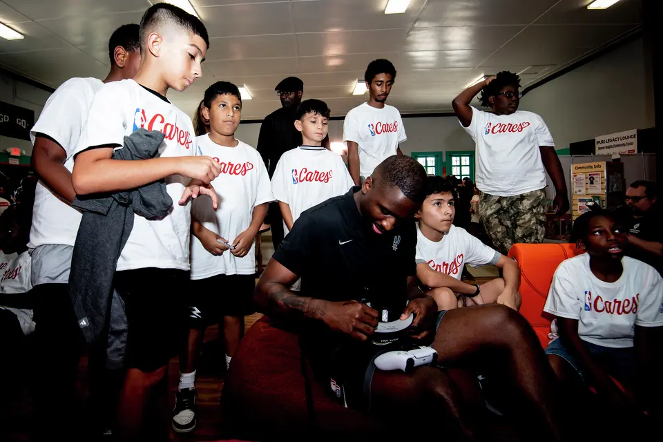 San Antonio Spurs player David Jones Garcia signs an autograph during the Legacy Project NBA Cares event at the Denver Heights Community Center on Thursday.
