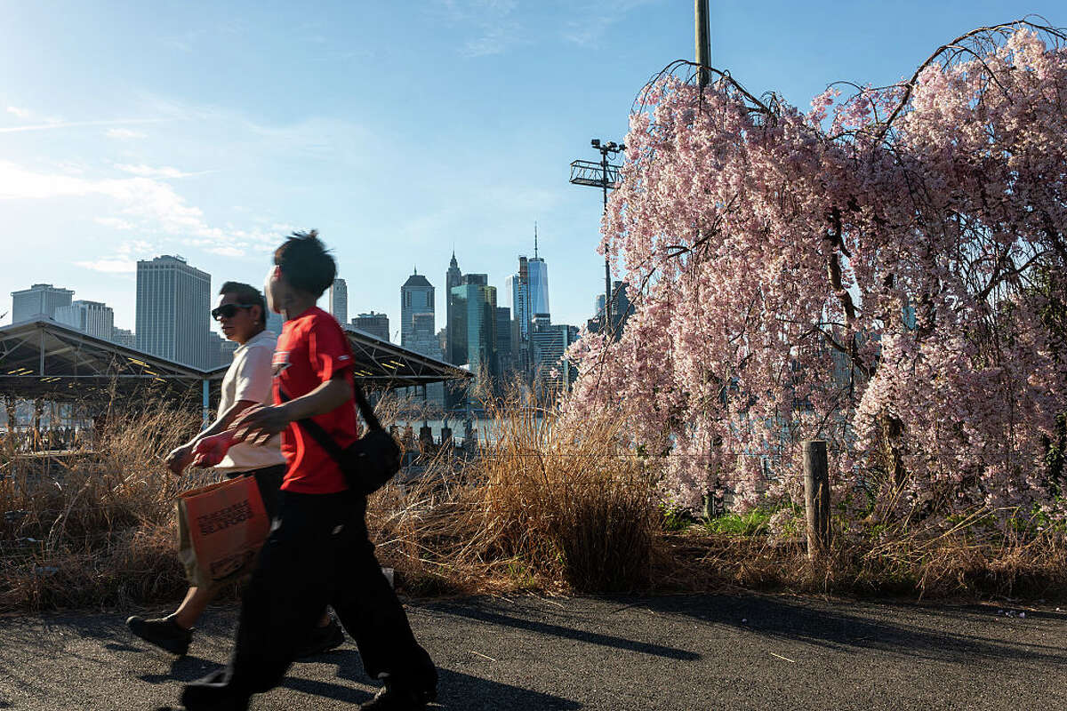 NEW YORK, NEW YORK - APRIL 14: People enjoy a walk in the afternoon at Brooklyn Bridge Park on April 14, 2026 in New York City. Temperatures in New York City reached the mid-80s on Tuesday, bringing summer-like weather earlier than usual to the area. (Photo by Spencer Platt/Getty Images)