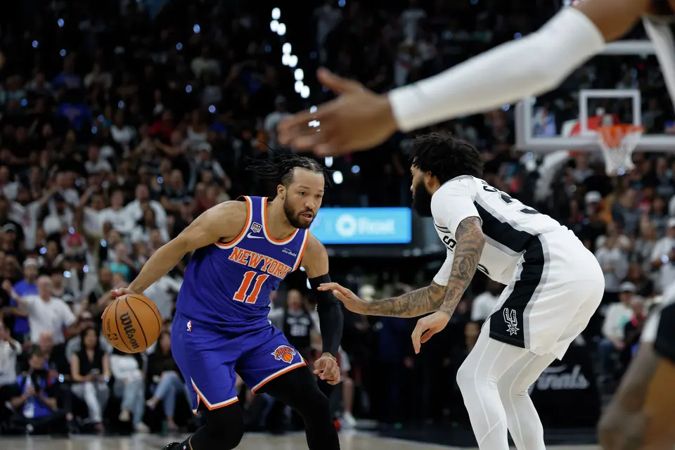 New York Knicks guard Jalen Brunson (11) brings the ball up the court while being defended by San Antonio Spurs forward Julian Champagnie (30) during the first quarter of Game 2 of the NBA Championship at Frost Bank Center in San Antonio on Friday, June 5, 2026.