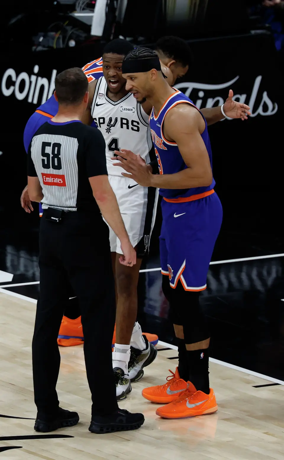 San Antonio Spurs guard De'Aaron Fox (4) and New York Knicks guard Josh Hart (3) try to convince referee Josh Tiven (58) of their respective positions during the second quarter of Game 2 of the NBA Championship at Frost Bank Center in San Antonio on Friday, June 5, 2026.