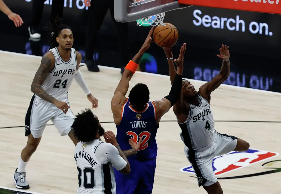 New York Knicks center Karl-Anthony Towns (32) and San Antonio Spurs guard De'Aaron Fox (4) fight for a rebound during the second quarter of Game 2 of the NBA Championship at Frost Bank Center in San Antonio on Friday, June 5, 2026.