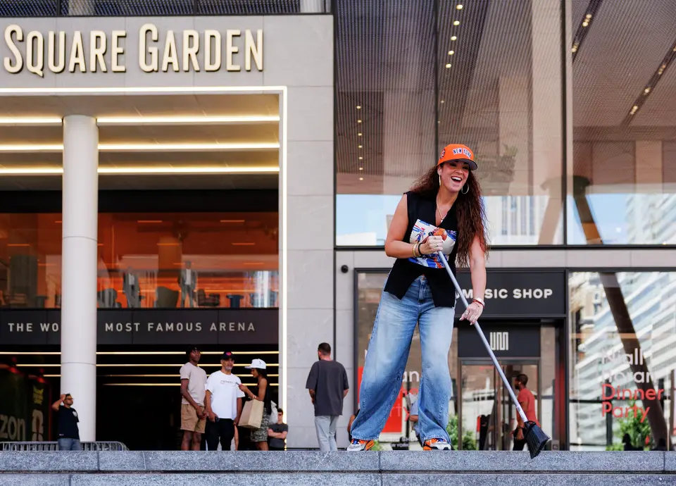 A New York Knicks fan pretends to sweeps the steps outside of Madison Square Garden in New York, Monday, June 8, 2026, ahead of Game 3 of the NBA Finals between the San Antonio Spurs and the New York Knicks.