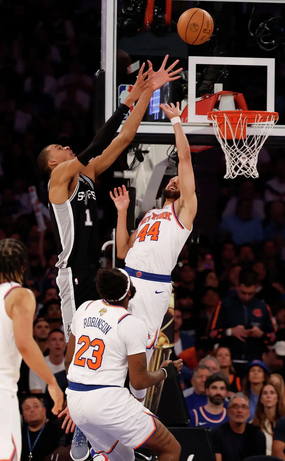 San Antonio Spurs center Victor Wembanyama (1) grabs a rebound over New York Knicks guard Landry Shamet (44) and New York Knicks center Mitchell Robinson (23) during the third quarter of Game 3 of the NBA Finals at Madison Square Garden in New York, Monday, June 8, 2026.