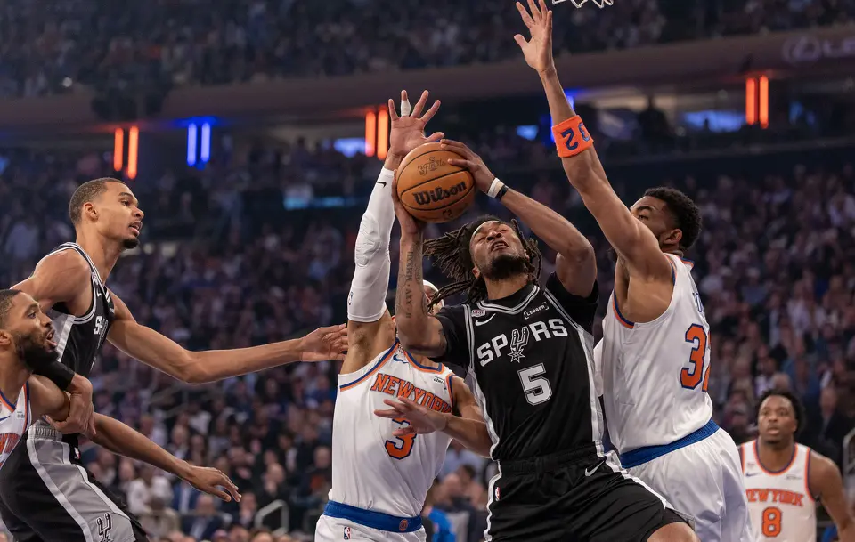 San Antonio Spurs guard Stephon Castle (5) makes a layup while being guarded by New York Knicks guard Josh Hart (3) and New York Knicks center Karl-Anthony Towns (32) during the first half of game three of the NBA Championship at Madison Square Garden in New York City on Monday, June 8, 2026.