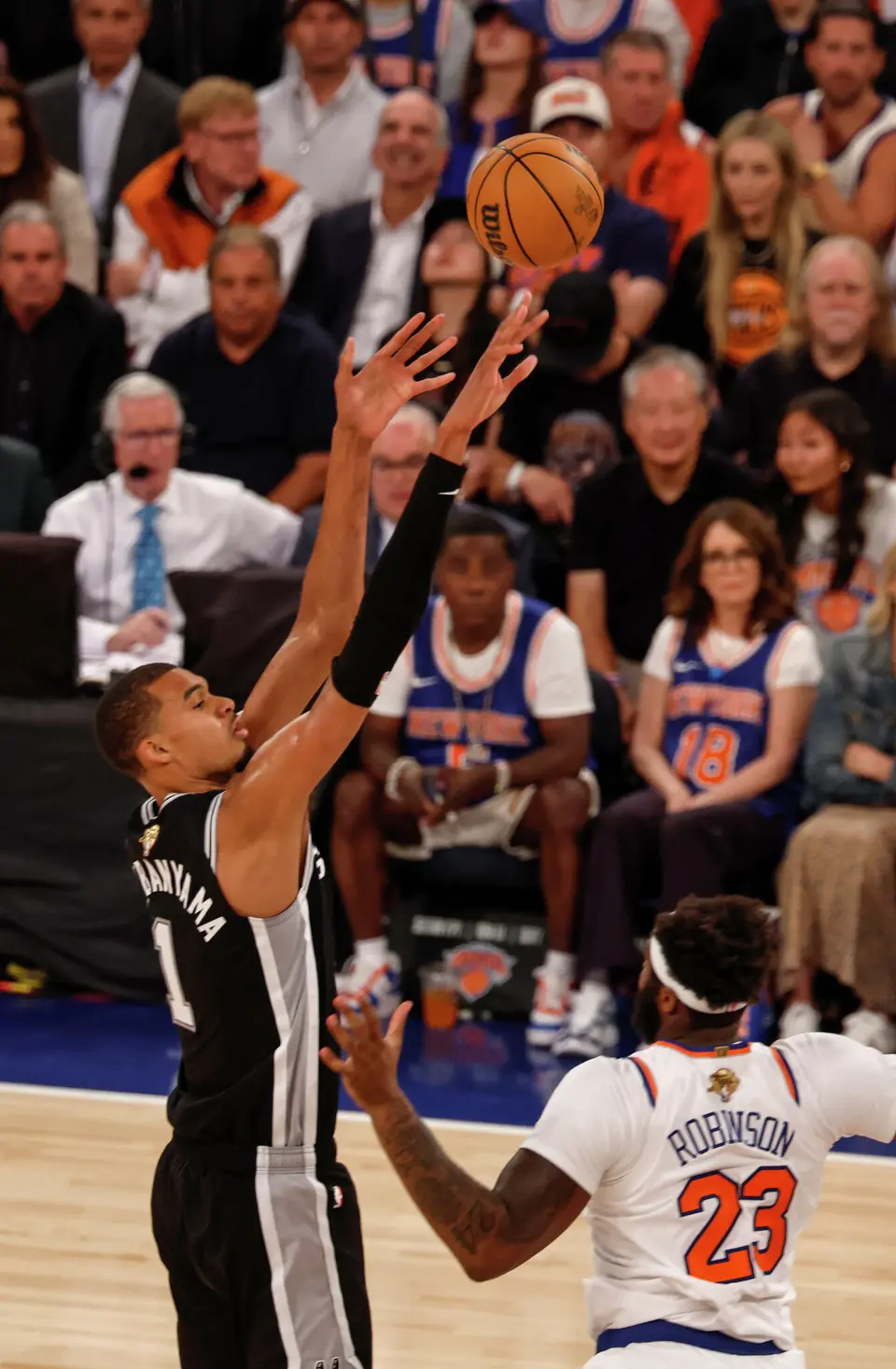 San Antonio Spurs center Victor Wembanyama (1) shoots a three point shot over New York Knicks center Mitchell Robinson (23) during the fourth quarter of Game 3 of the NBA Finals at Madison Square Garden in New York, Monday, June 8, 2026. The Spurs defeated the Knicks 115-111.