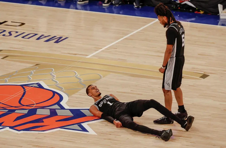 San Antonio Spurs guard Stephon Castle (5) goes over to help a wincing Spurs center Victor Wembanyama (1) after falling on his back during the fourth quarter of Game 3 of the NBA Finals at Madison Square Garden in New York, Monday, June 8, 2026. The Spurs defeated the Knicks 115-111.