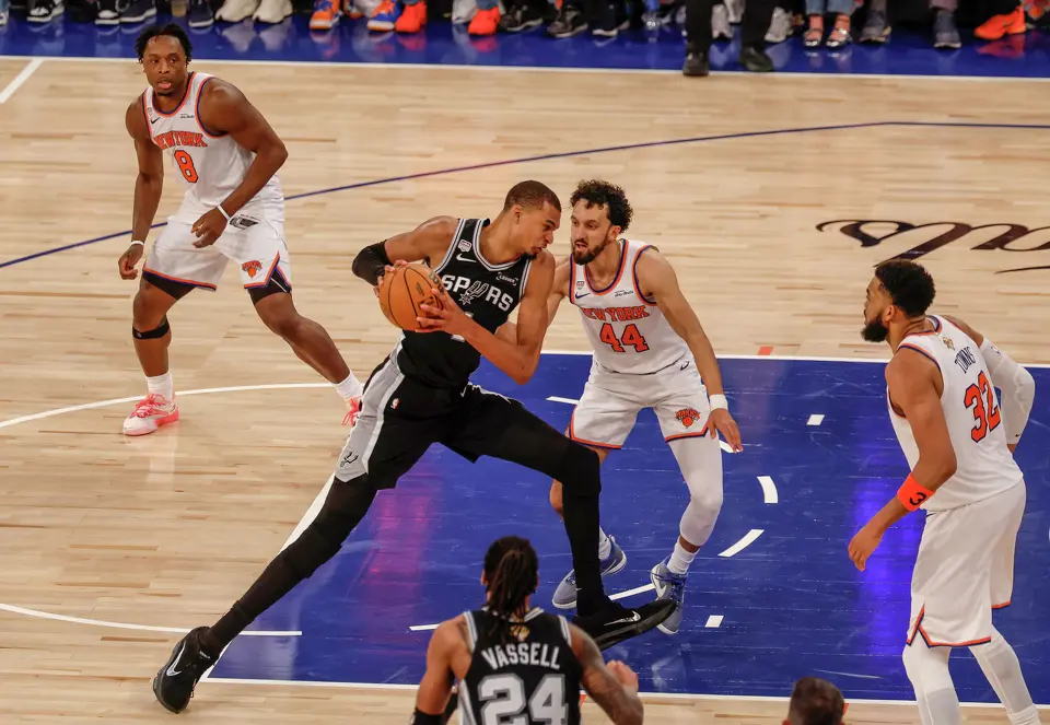 San Antonio Spurs center Victor Wembanyama (1) lowers his shoulder and drives to the basket while being guarded by New York Knicks guard Landry Shamet (44) during the fourth quarter of Game 3 of the NBA Finals at Madison Square Garden in New York, Monday, June 8, 2026. The Spurs defeated the Knicks 115-111.