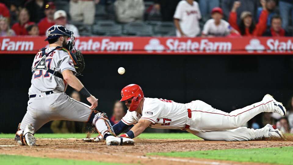 Los Angeles Angels' Mike Trout, right, slides into home base, but is called out during the 10th inning of a baseball game against the Houston Astros, Monday, June 8, 2026, in Anaheim, Calif. (AP Photo/William Liang)